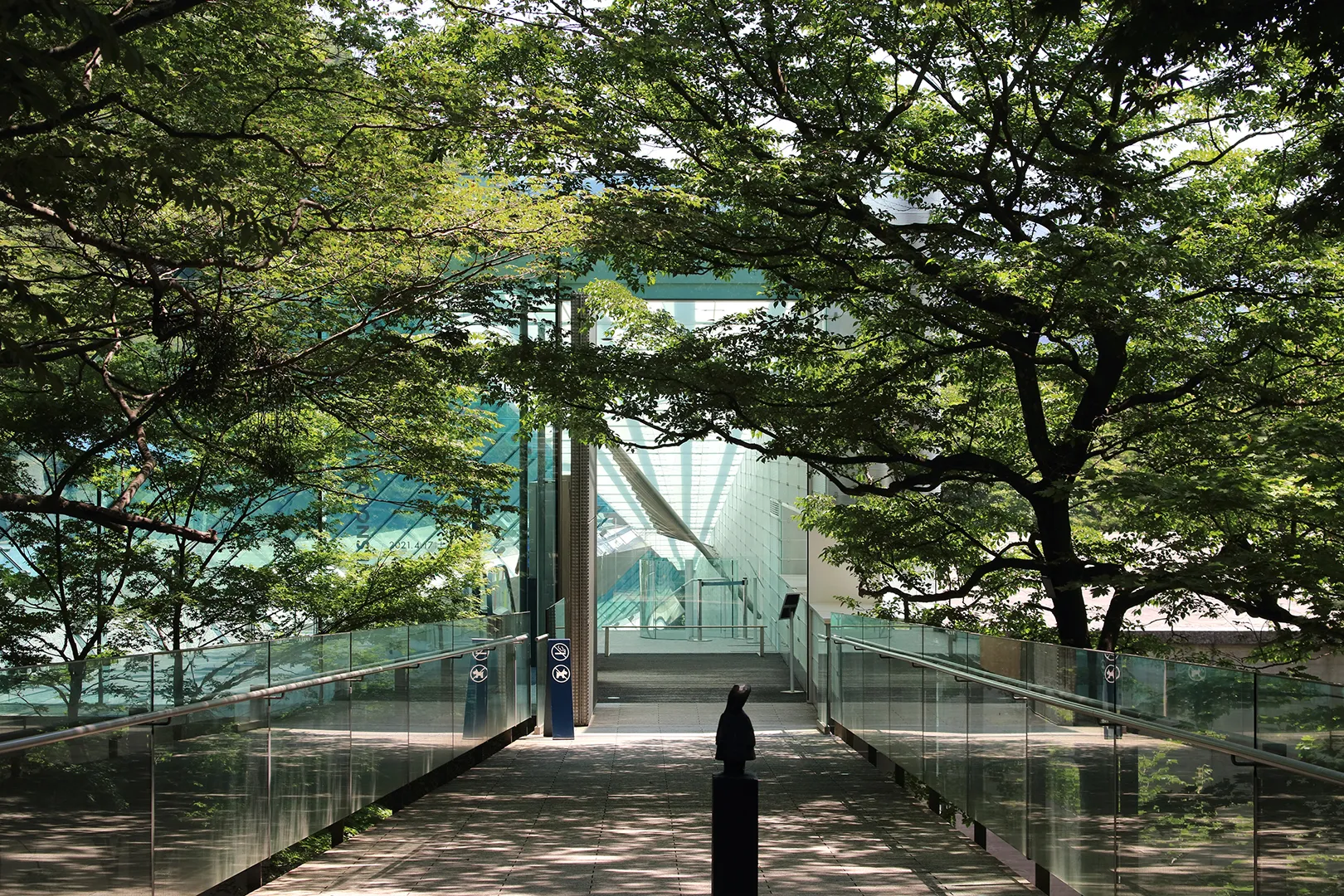 「The modern entrance to the Pola Museum of Art surrounded by forest」